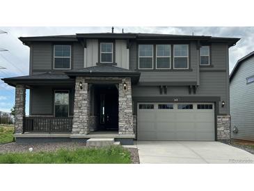 Charming two-story home featuring a gray exterior, stone accents, and a two-car garage at 3070 S Poppy St, Morrison, CO 80465