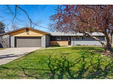 Charming single-story home featuring an attached garage and mature trees accenting the freshly mowed front lawn at 12345 W 32Nd Ave, Wheat Ridge, CO 80033