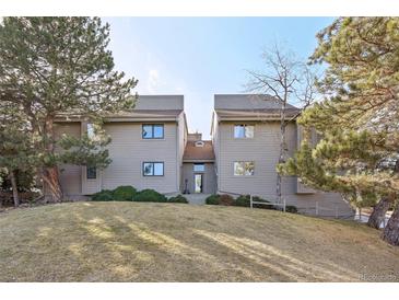 Inviting townhome featuring a well-manicured lawn and mature trees, showcasing its charming curb appeal at 23558 Pondview Pl # B, Golden, CO 80401