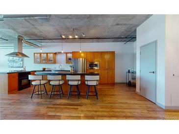 Modern kitchen with stainless steel appliances, breakfast bar, and ample cabinet space, perfect for culinary enthusiasts at 1401 Wewatta St # 808, Denver, CO 80202