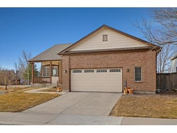 Charming single Gathering home with a brick facade, covered porch, and two-car garage at 1300 Iris Cir, Broomfield, CO 80020