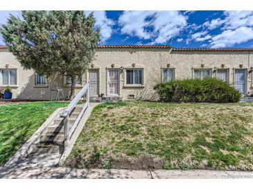 Charming row house with stucco exterior and small front yard and concrete stairway to the entrance at 3061 W 18Th Ave, Denver, CO 80204