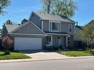 Charming two-story home with a well-manicured lawn, two-car garage, and traditional architectural details at 10064 Owens St, Broomfield, CO 80021