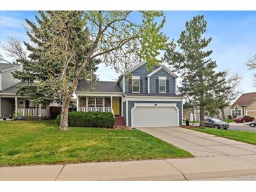 Charming two-story home features a well-manicured lawn, attached garage and delightful yellow front door at 8508 Vivian Ct, Arvada, CO 80005