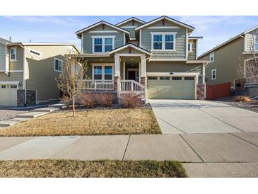 Inviting two-story home with a covered porch, attached garage, and well-maintained lawn in a suburban neighborhood at 14881 Chicago St, Parker, CO 80134