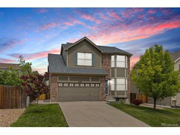 Two-story home with brick and siding, a two-car garage, and a well-manicured lawn at 5733 S Yakima Way, Aurora, CO 80015