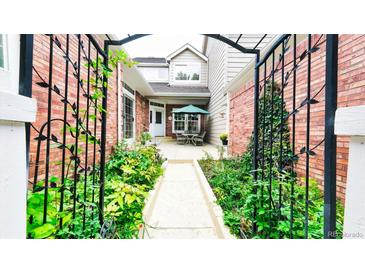 Beautifully landscaped courtyard with wrought iron details creating a welcoming outdoor space at 9873 Greensview Cir, Lone Tree, CO 80124