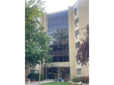 Apartment building featuring a grand two-story entrance with floor-to-ceiling windows, exterior landscaping, and clearly visible signage at 13601 E Marina Dr # 508, Aurora, CO 80014