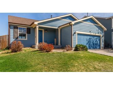 Charming blue home featuring a well-manicured lawn, front entry porch and attached garage at 5530 Lewiston Ct, Denver, CO 80239