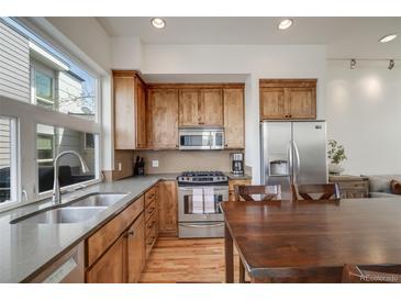 Modern kitchen with stainless steel appliances, wood cabinets, and a large window offering lots of natural light at 2607 W 24Th Ave, Denver, CO 80211