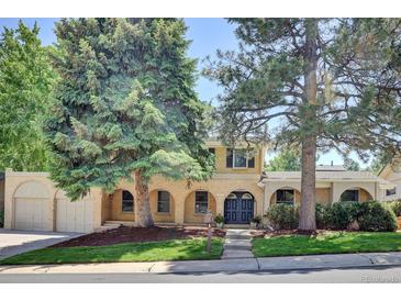 Charming two-story home with well-maintained lawn and mature trees enhancing curb appeal at 7504 E Jefferson Dr, Denver, CO 80237