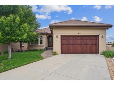 Charming single-story home featuring a well-manicured lawn, a two-car garage, and a welcoming entrance at 4775 S Anaheim Ct, Aurora, CO 80015