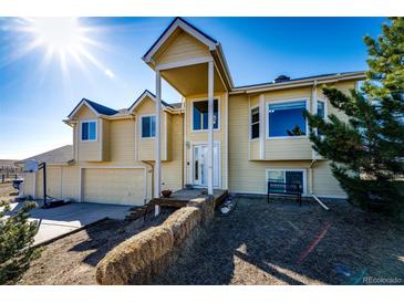 Charming two-story home with a large front porch and attached two-car garage in a rural setting at 7440 S Shenandoah Dr, Elizabeth, CO 80107