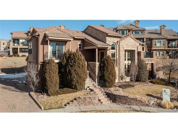 Multi-story home with stone accents, well-maintained landscaping, and a welcoming front entrance at 9228 Sori Ln, Highlands Ranch, CO 80126