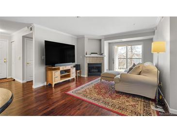 Cozy living room with a fireplace, hardwood floors and light neutral color scheme at 12158 W Dorado Pl # 205, Littleton, CO 80127