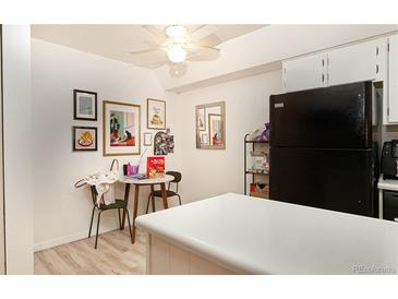 Bright kitchen featuring laminate flooring, stylish decorations, and modern black refrigerator at 5995 W Hampden Ave # 3H, Denver, CO 80227