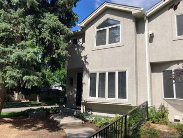 Charming two-story townhome featuring stucco exterior, large windows, and mature landscaping in a desirable neighborhood at 490 Jackson St, Denver, CO 80206