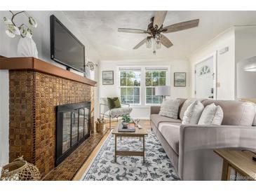 Bright living room with fireplace, hardwood floors, and comfortable seating at 7121 W 52Nd Ave, Arvada, CO 80002