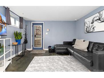 Modern living room with stylish gray walls, a black leather couch, and decor at 1310 N Corona St # A, Denver, CO 80218