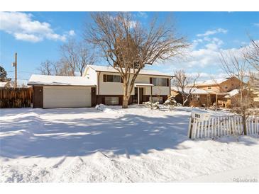 Snow covered lawn and charming ranch home with attached garage at 995 S Upham St, Lakewood, CO 80226