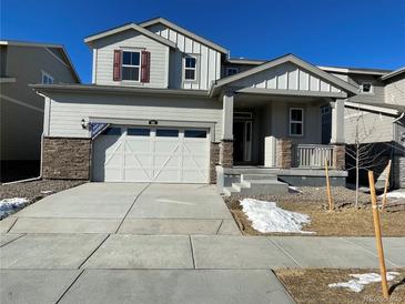 Two-story house with attached garage, stone accents, and a landscaped yard at 191 Freemont Ct, Brighton, CO 80601