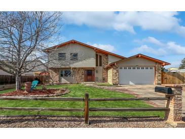 Charming two-story home with brick and siding, well-manicured lawn, and a fenced yard at 85 Yank Way, Lakewood, CO 80228