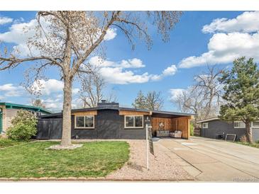 Charming single-story home featuring a black brick exterior, well-kept lawn, and covered seating area at 6170 Estes Ct, Arvada, CO 80004
