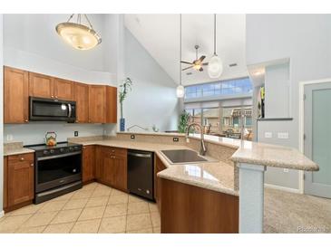 Modern kitchen with stainless steel appliances, granite countertops, and natural light from a large window at 8627 Gold Peak Pl # C, Highlands Ranch, CO 80130