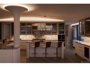 Bright, modern kitchen with marble counters, crystal chandelier, and counter seating at 1133 14Th St # 3430, Denver, CO 80202