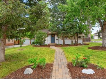 Charming single story home with a brick walkway, lush lawn and mature trees at 2680 S Garfield Cir, Denver, CO 80210