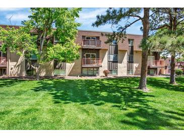 Exterior view of the home featuring a well-manicured lawn and balconies at 7755 E Quincy Ave # 206, Denver, CO 80237