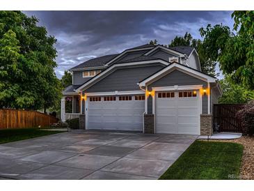 Charming two-story home with a gray exterior, a two-car garage, and a well-manicured lawn at 6358 S Miller Way, Littleton, CO 80127