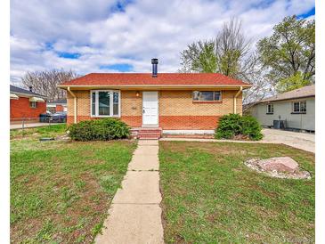 Charming brick home with a well-maintained lawn and walkway leading to the front door at 6990 Larsh Dr, Denver, CO 80221