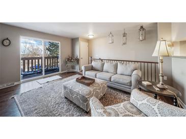 Bright living room with hardwood floors, comfy seating, and a view to the kitchen at 7700 W Glasgow Pl # 19C, Littleton, CO 80128