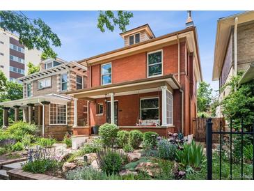 Charming two-story brick home with a landscaped front yard and inviting porch swing at 1007 N Ogden St, Denver, CO 80218