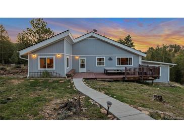 Charming single-story home boasts a spacious deck and inviting outdoor dining area, perfect for enjoying scenic views at 11348 Ranch Elsie Rd, Golden, CO 80403