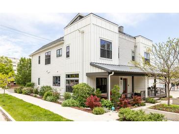 Modern two-story home with white siding, black windows, and covered front porch with landscaped yard at 801 8Th St, Golden, CO 80401