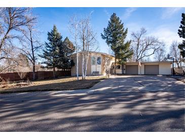 Ranch style home with attached two-car garage and mature trees at 8010 W Chestnut Dr, Littleton, CO 80128