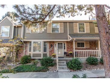 Charming two-story townhome with a brick facade, mature landscaping, and a cozy front porch at 6839 E Briarwood Dr, Centennial, CO 80112