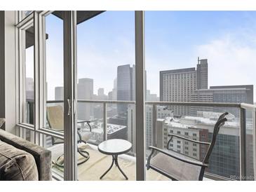 Balcony overlooking the city skyline with a glass railing and outdoor seating area at 891 14Th St # 2712, Denver, CO 80202