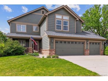 Charming two-story home with a three-car garage, well-manicured lawn, and inviting curb appeal at 16662 W 61St Pl, Arvada, CO 80403