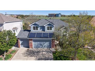 Charming two-story home with a gray roof, brick accents, solar panels, and a two-car garage at 9567 W 107Th Dr, Broomfield, CO 80021
