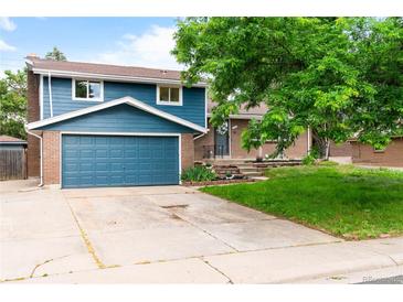 Charming two-story home with a blue exterior, brick accents, an attached garage, and a well-maintained front yard at 544 S Victor Way, Aurora, CO 80012