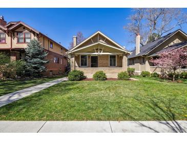 Charming bungalow featuring a brick facade, well-maintained lawn, and inviting front porch at 1111 S Corona St, Denver, CO 80210
