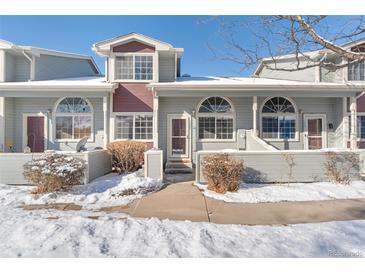 Two-story townhome with snow-covered walkway and landscaping at 1805 W 101St Ave, Thornton, CO 80260