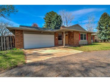 Brick home featuring a two-car garage and manicured landscaping at 1705 Stonehenge Dr, Lafayette, CO 80026