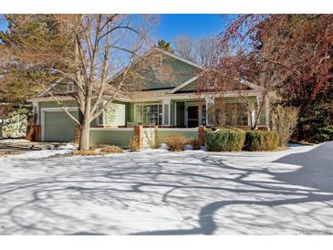 Green two-story house with a snow covered front yard at 1894 S Marshall Cir, Lakewood, CO 80232