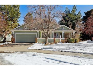 Green two-story house with a snow covered front yard and a red front door at 1894 S Marshall Cir, Lakewood, CO 80232