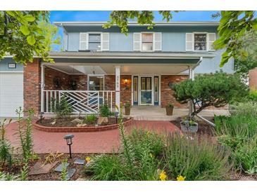 Charming two-story home with a brick facade, a welcoming front porch and professionally landscaped yard at 3765 E Easter Dr, Centennial, CO 80122