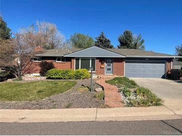 Charming brick home with manicured front yard and cozy, inviting curb appeal on a sunny day at 6176 S Adams Dr, Centennial, CO 80121